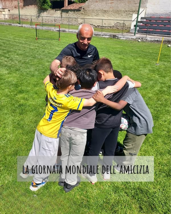 Un allenatore e un gruppo di bambini si stringono in cerchio sul campo